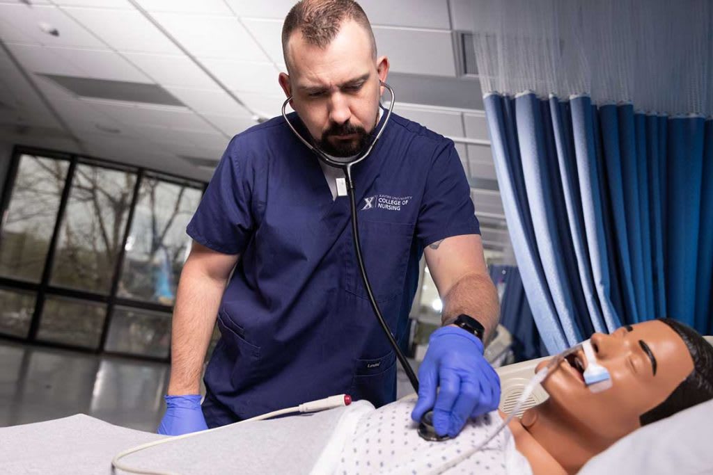 Xavier nursing student working with sim manikin