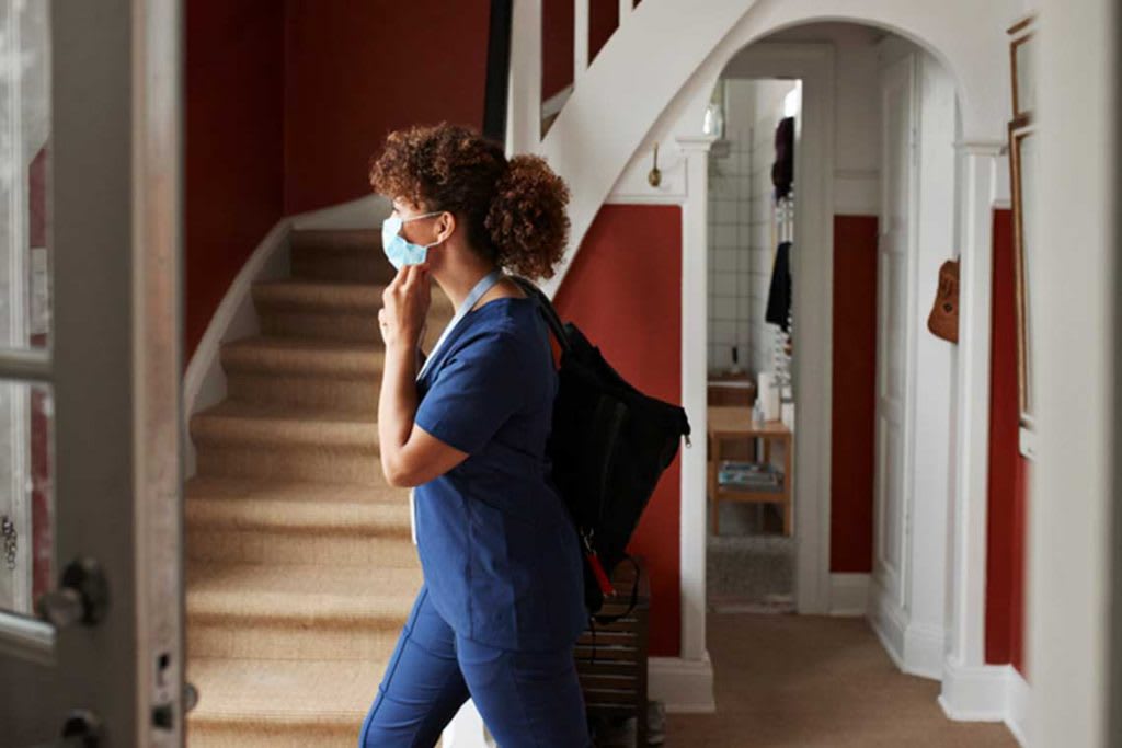 nursing student walking in hall putting on mask