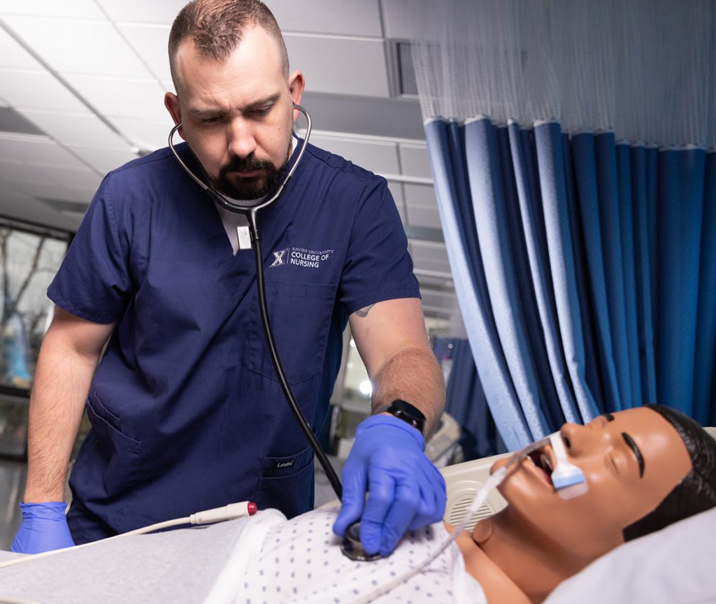 nurse using stethoscope on manikin