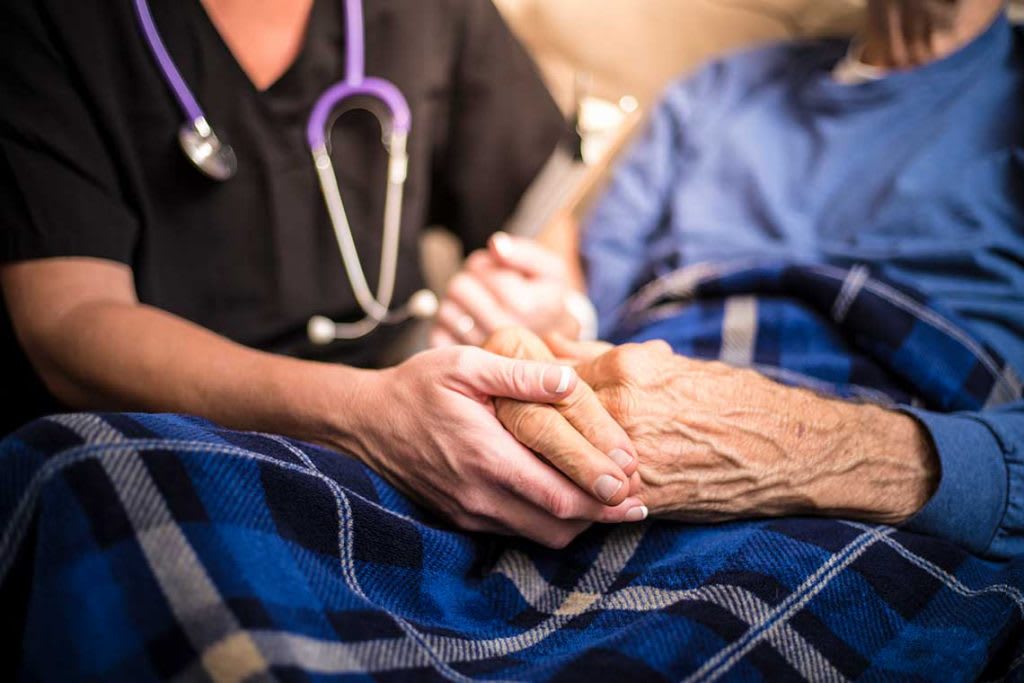 nurse holding elderly patient's hands