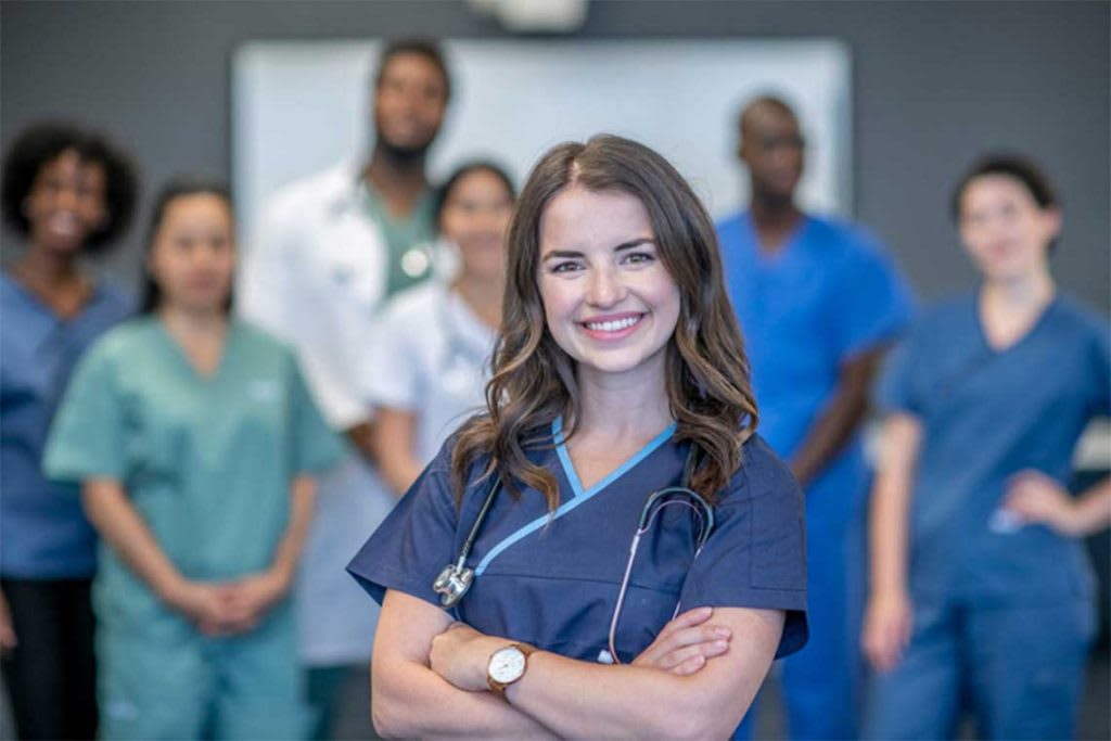 nursing smiling standing in front of other nurses