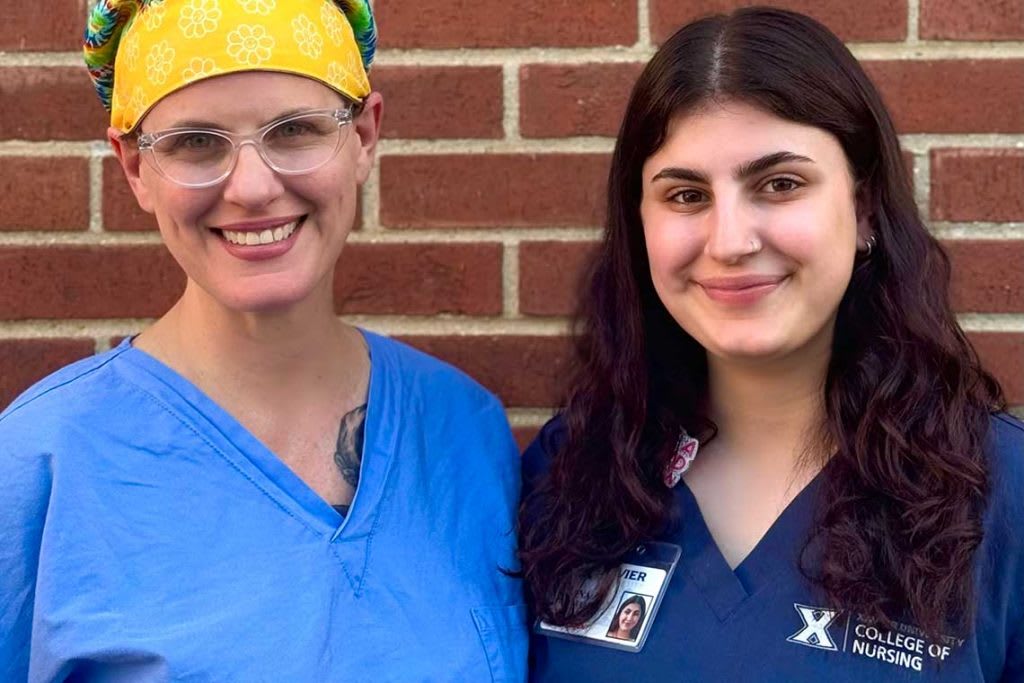 two nurses standing by brick wall