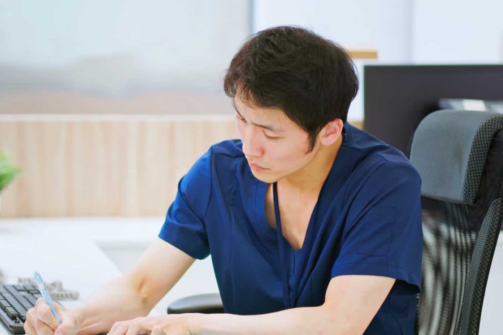 nurse sitting at table writing