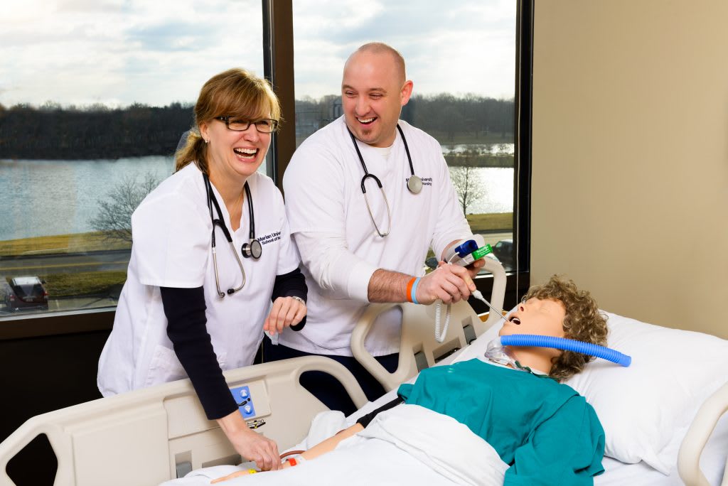 Accelerated Nursing Students practicing with simulation manikin