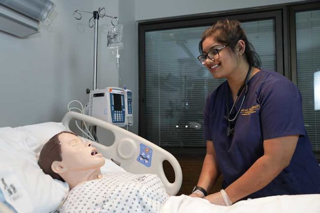 nursing student working with simulation manikin