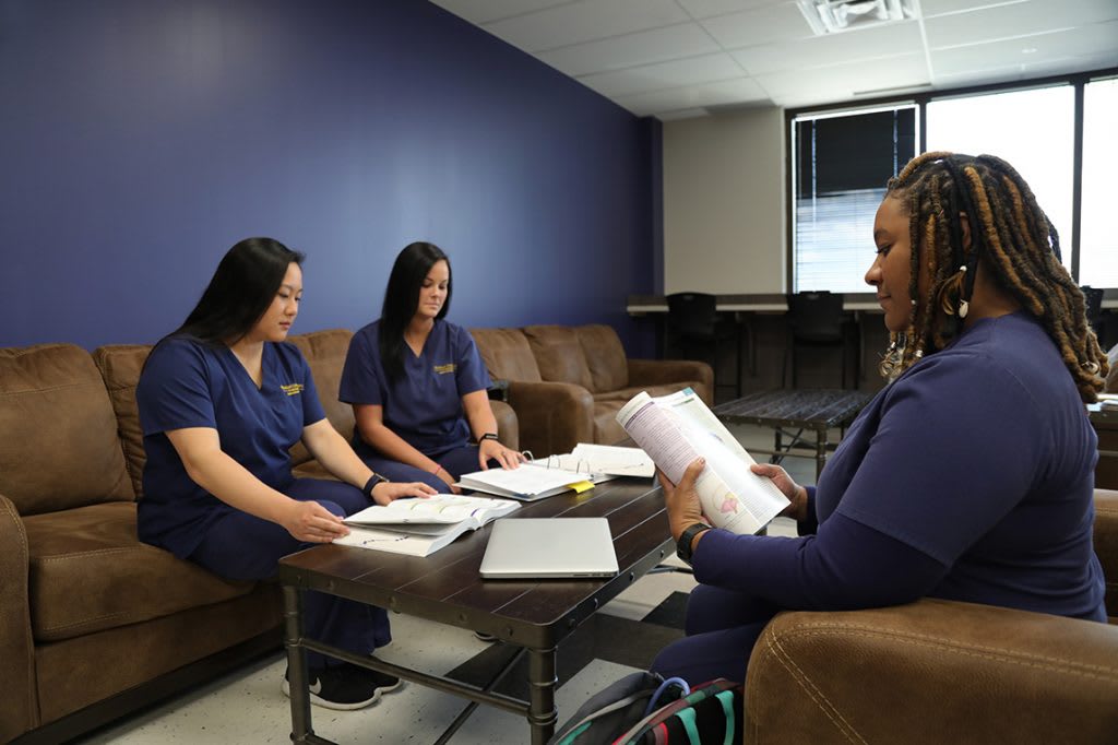 three nursing students sitting in room studying