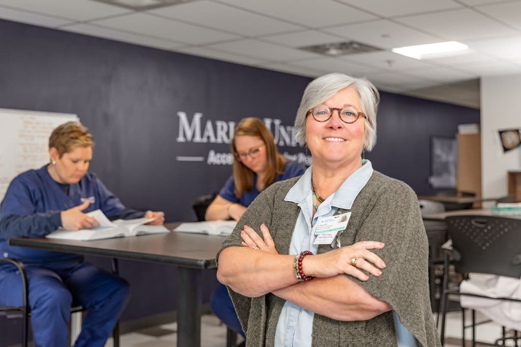 smiling portrait of Marian professor with arms crossed