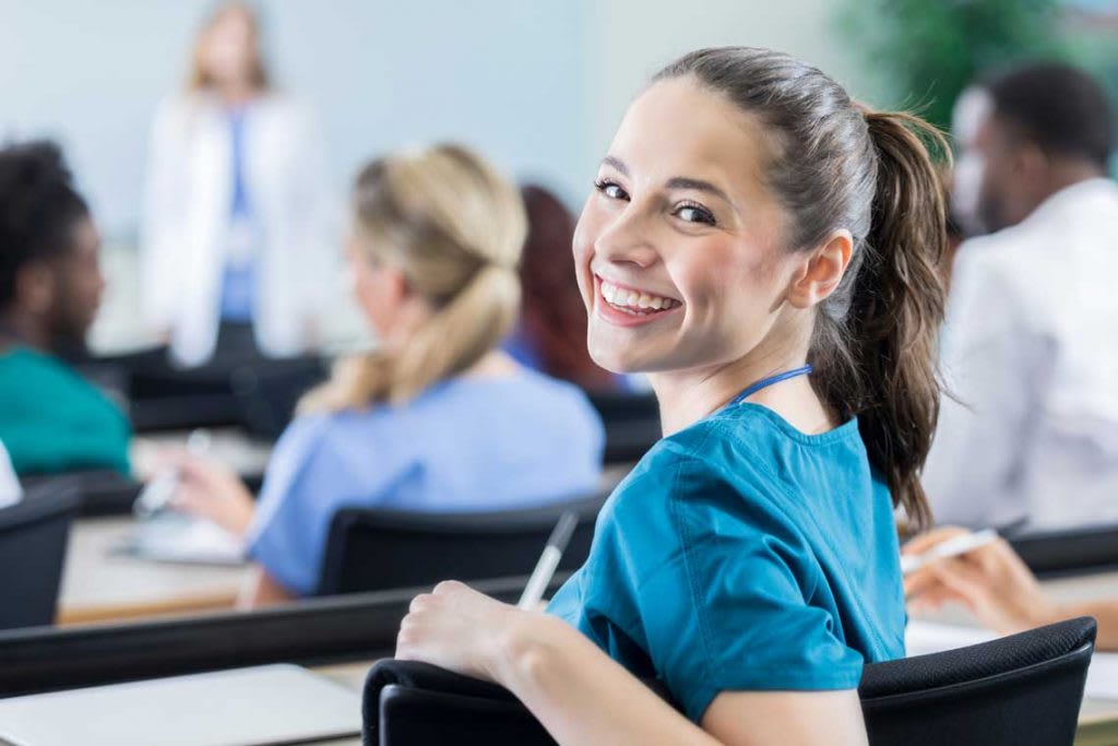 nurse sitting in class smiling at camera