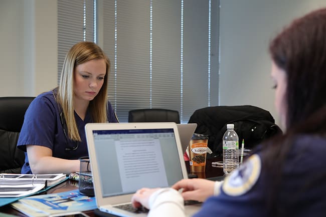 two marquette students studying on their computers