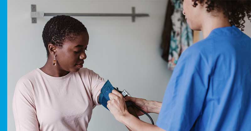 nurse helping patient with blood pressure cuff