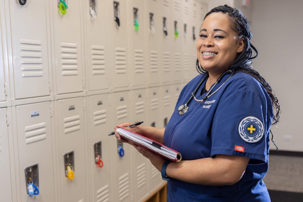 miling portrait of nursing student holding clipboard