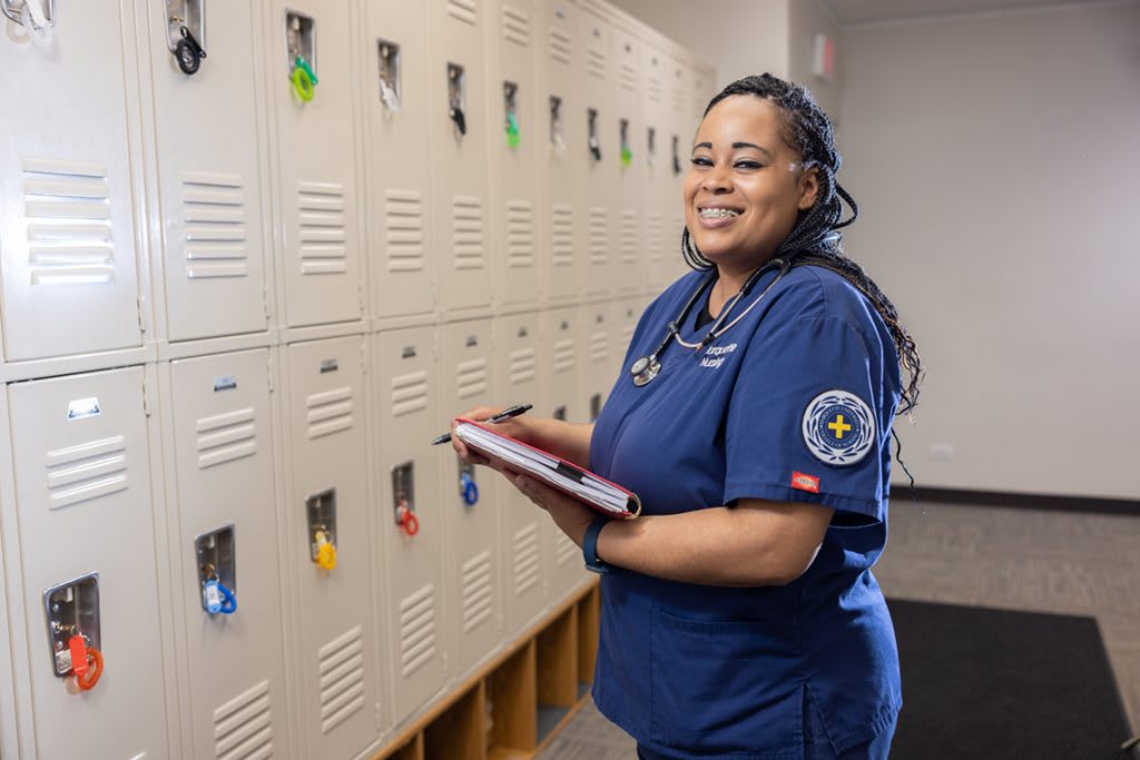 miling portrait of nursing student holding clipboard