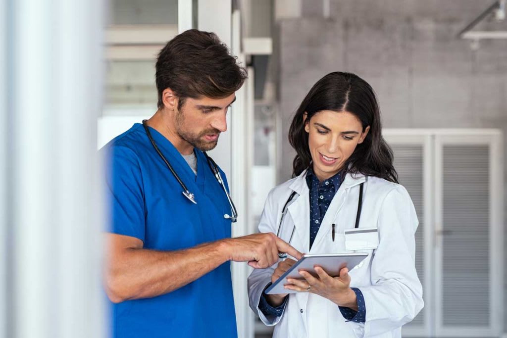 male nurse helping a doctor with patient chart