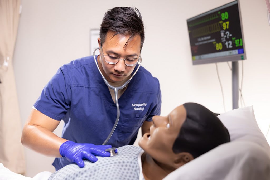 nurdsing student practicing on manikin with stethoscope