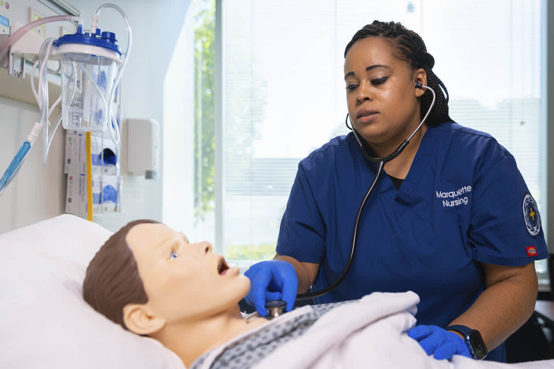 nursing student checking heart of mannequin