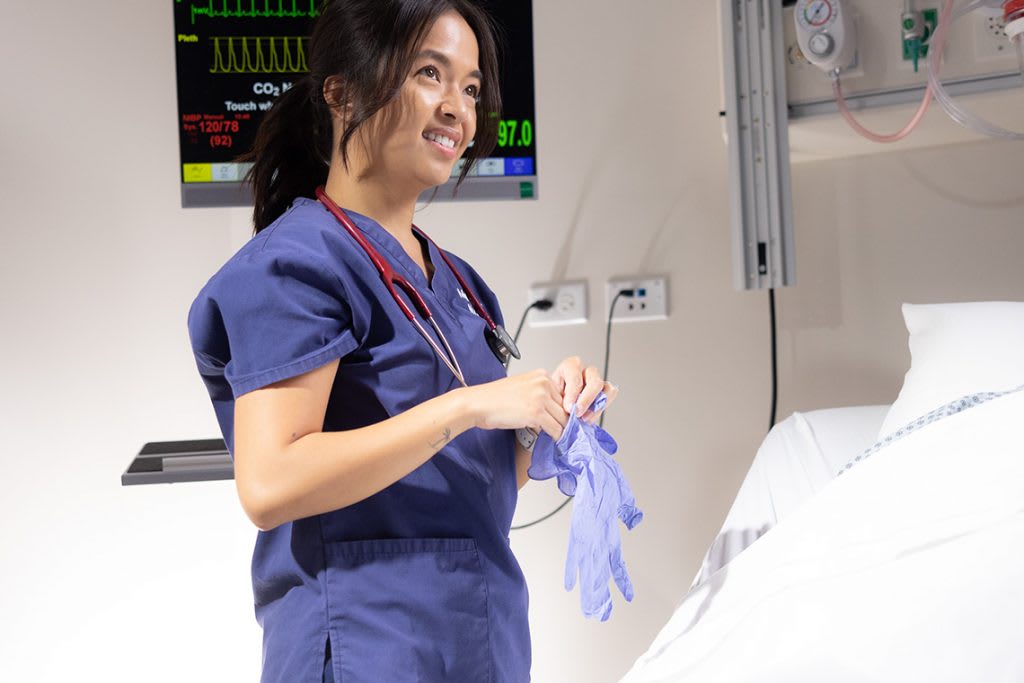 Marquette nursing student putting on gloves