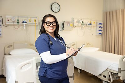 Student with clipboard in hospital room