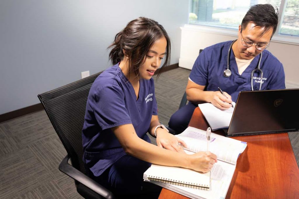 two nursing students at table studying