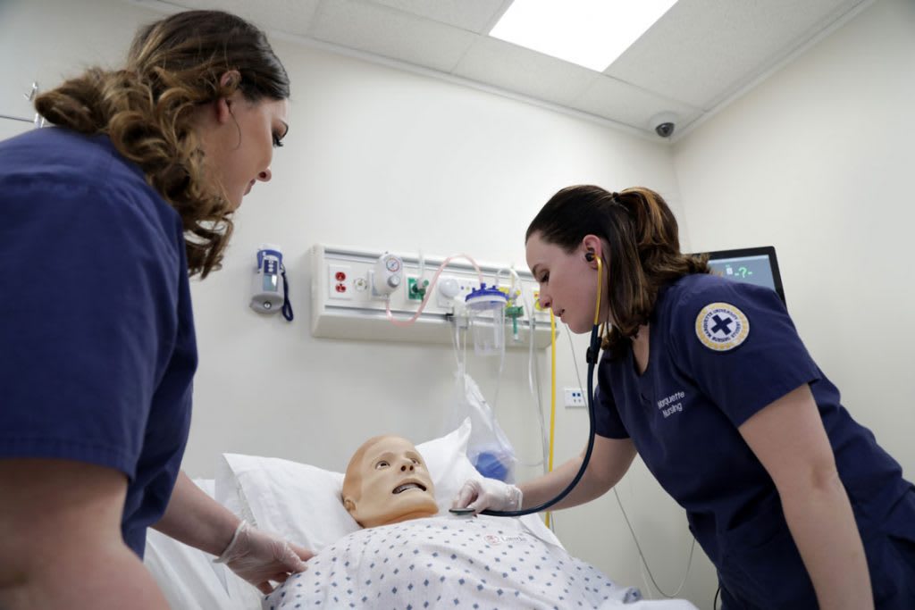 nursing students over manikin