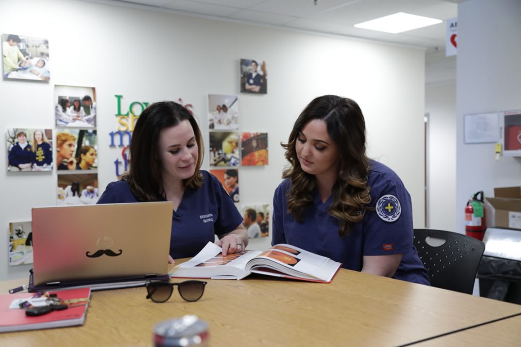 two nursing students studying at a table