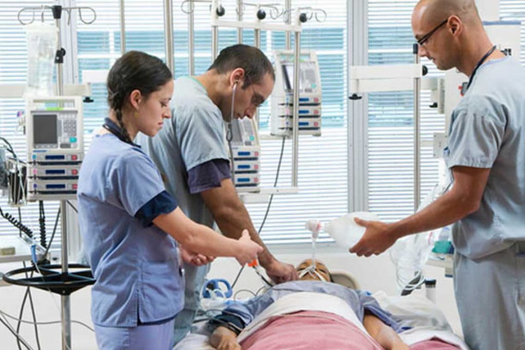 doctor with nurses around a patient on bed with monitors