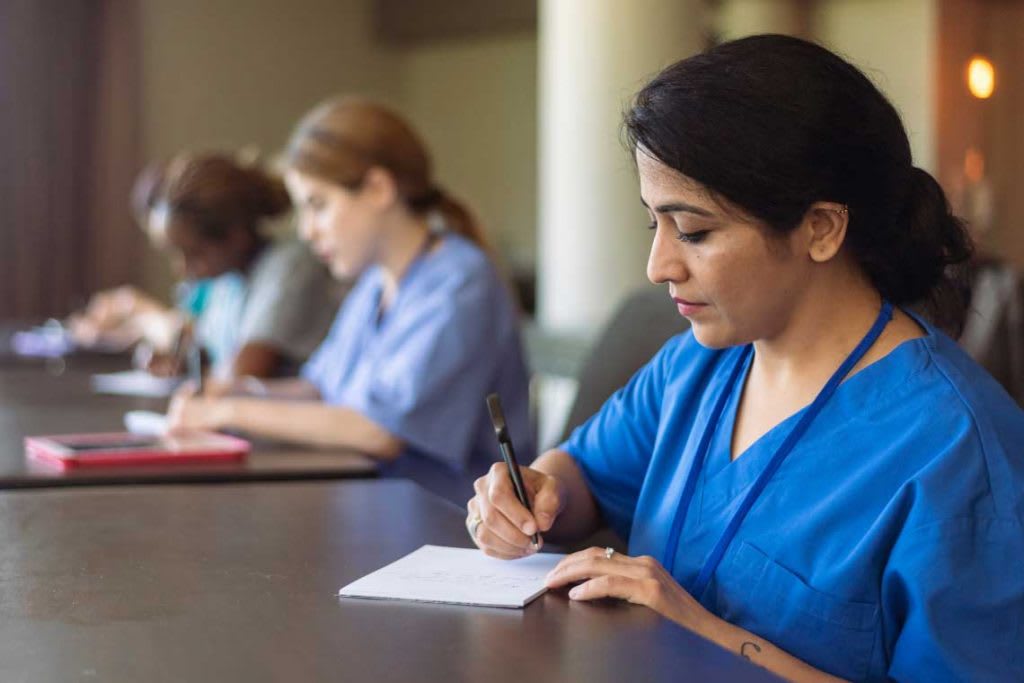 nurse taking notes at a desk