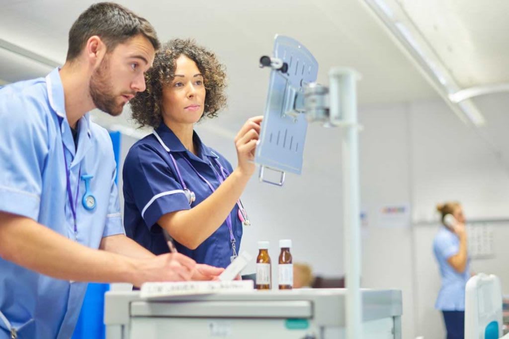 nurses in hospital looking at computer display