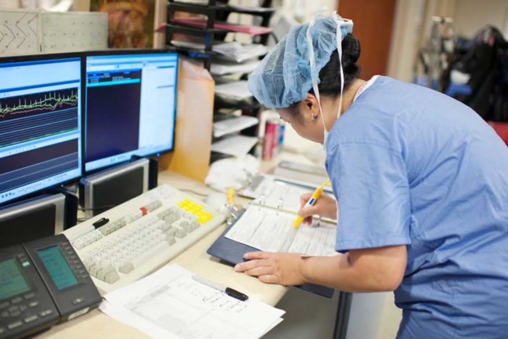 nurse writing in binder