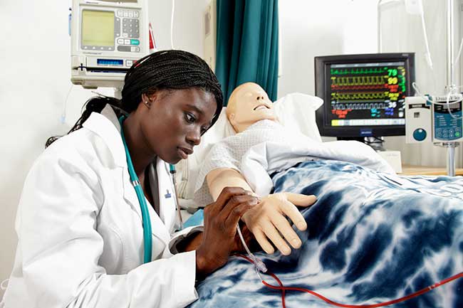 Nursing student practicing on sim manikin