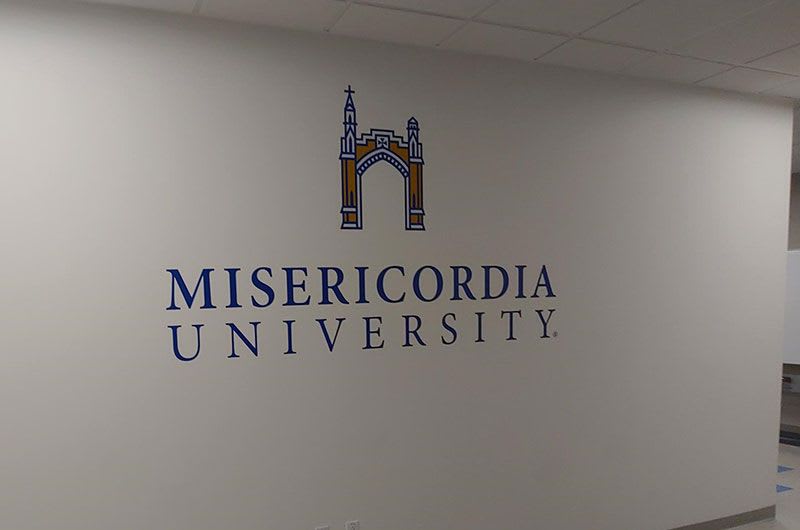 Wall display of Misericordia logo in hallway