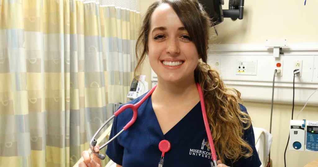 ABSN student in scrubs with stethoscope