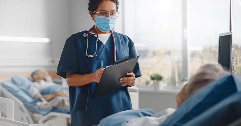 Nurse attending to patient in hospital room