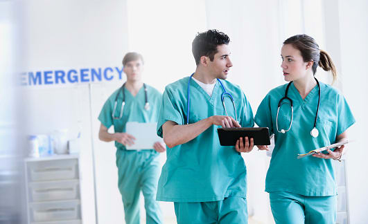 three nurses walking in hallway