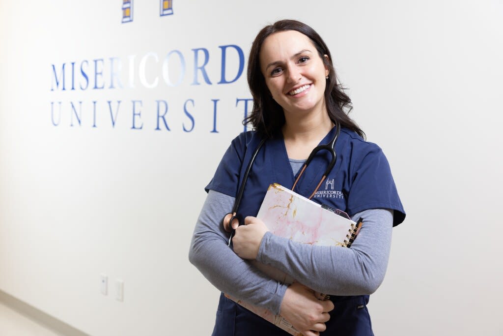 smiling nursing student standing in hallway