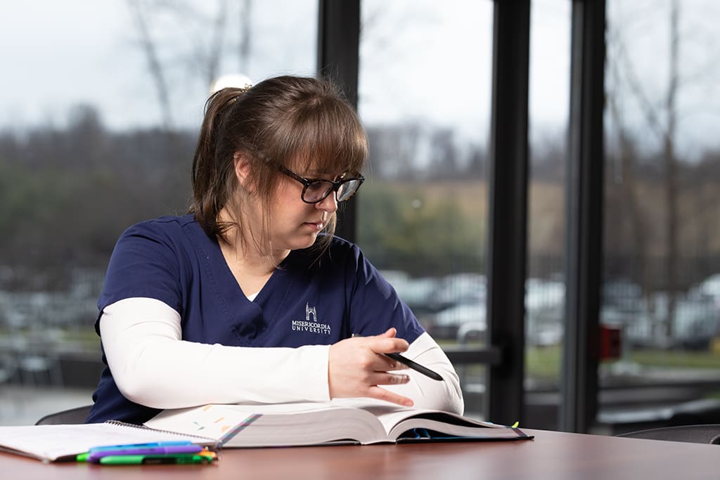 nursing student sitting at desk studying