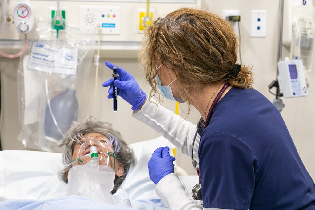 nursing student in simulation lab working with manikin