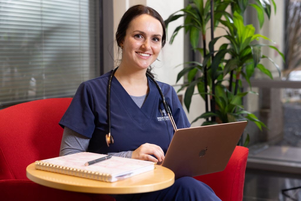 Misericordia nursing student sitting and working on laptop