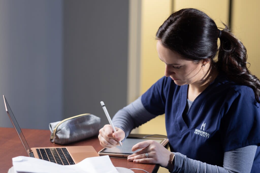 Misericordia nursing student studying and writing on digital tablet