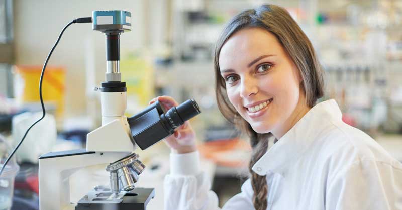 student looking into microscope