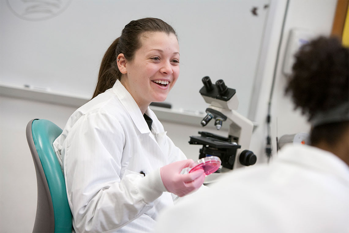 Medical laboratory science student holding petri dish