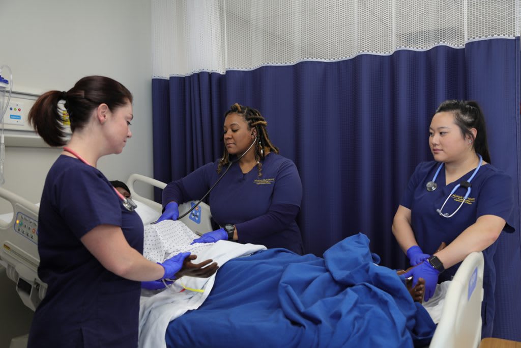 three Marian ABSN students in sim lab