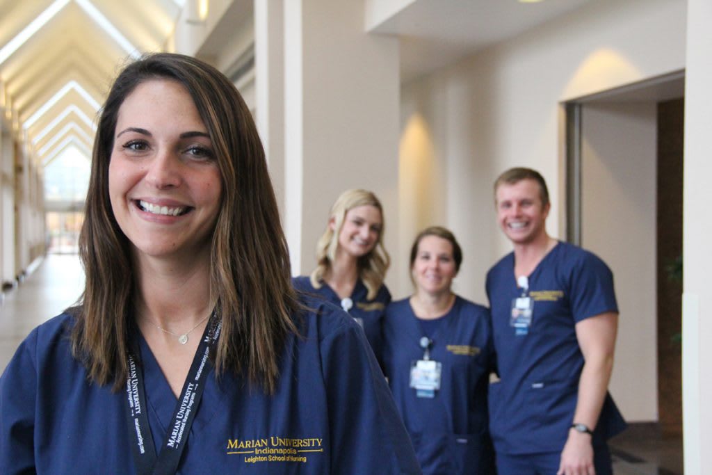 four Marian ABSN students smiling in hallway