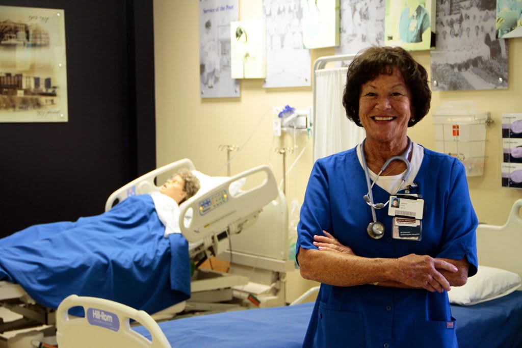 nursing student standing in sim lab smiling