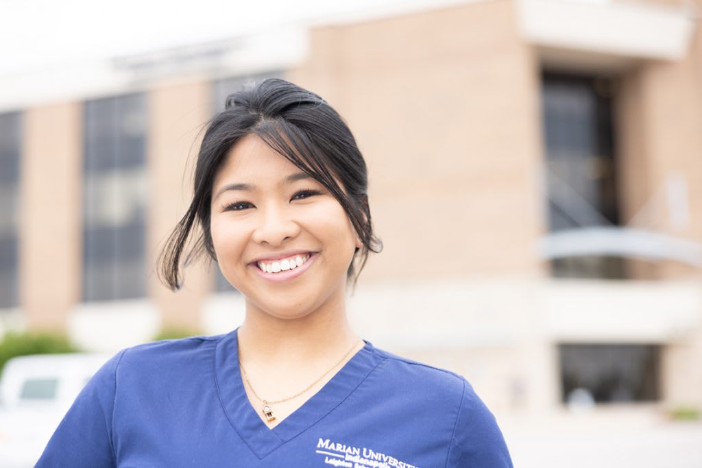 smiling nursing student standing outside
