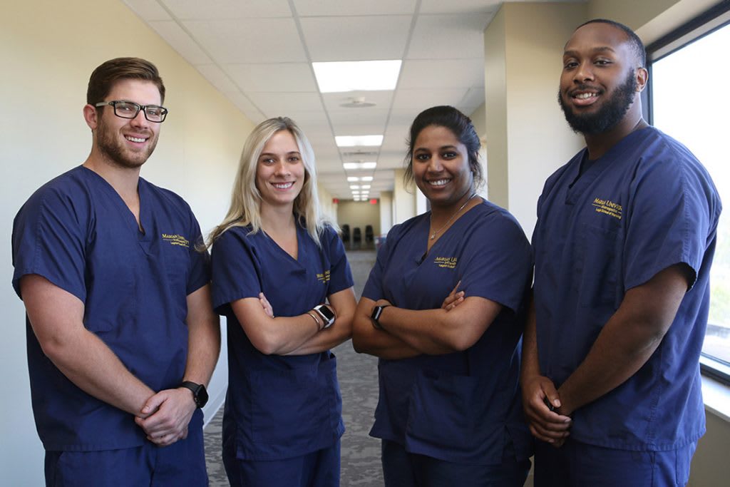 four Marian ABSN students standing together smiling
