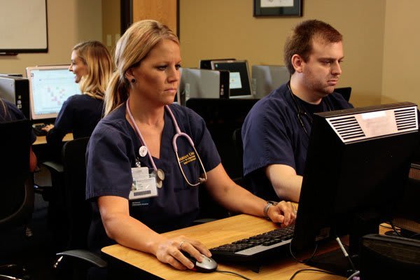 nursing students sitting at desks using computers