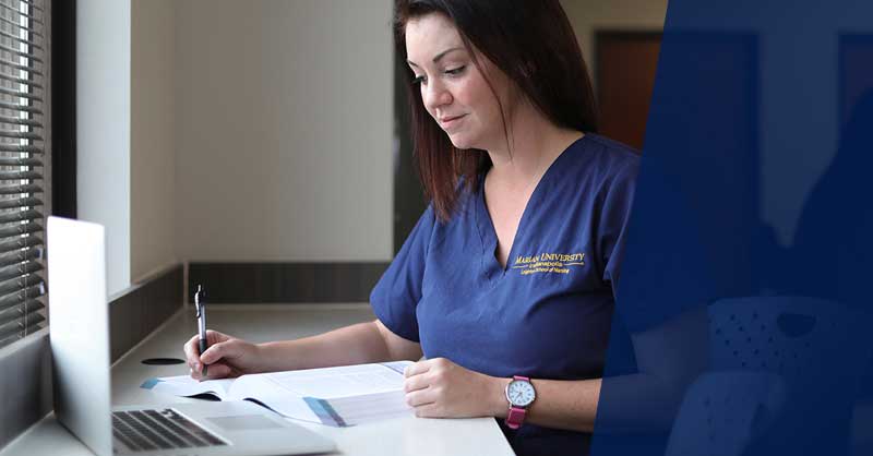 Marian ABSN student sitting at desk studying with a laptop