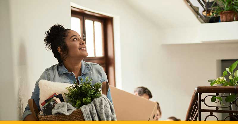 woman carrying things while climbing up stairs