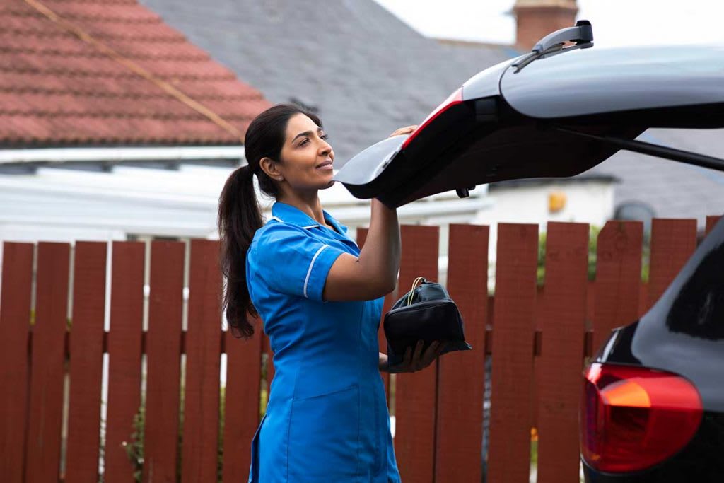 nurse outside packing the back of her car