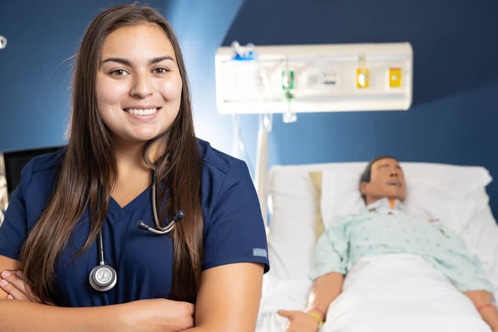 nursing student in front of mannequin